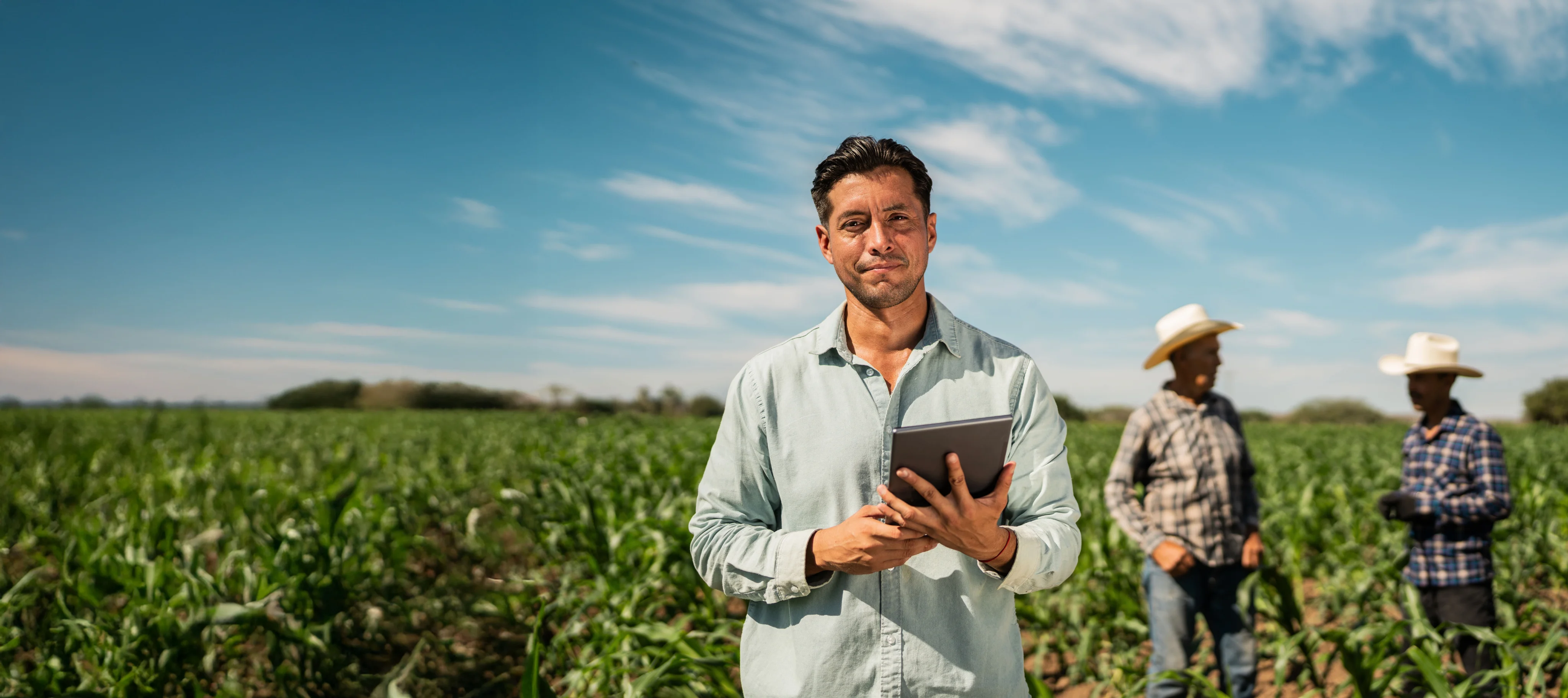 Homem segurando tablet em meio a plantacao
